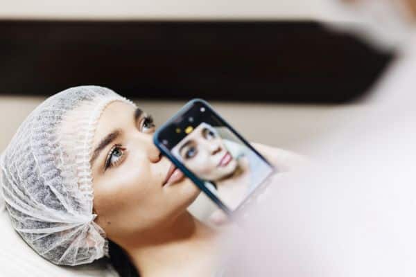Cosmiatria e beleza - mulher preparada para tratamento facial, sendo fotografada com um celular.