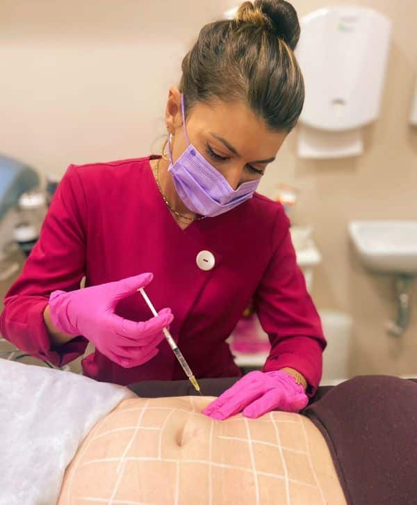 Fisioterapeuta realizando lipo enzimática em abdômen de paciente.