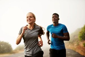 Um casal feliz realizando corrida num parque para atividades esportivas.