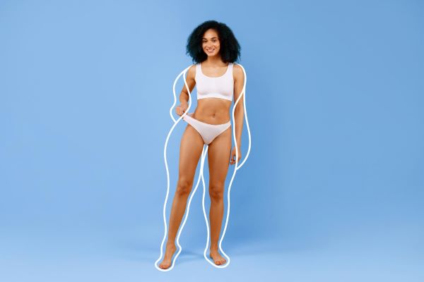 Mulher negra mostrando ótimos resultados da cirurgia plástica no corpo.